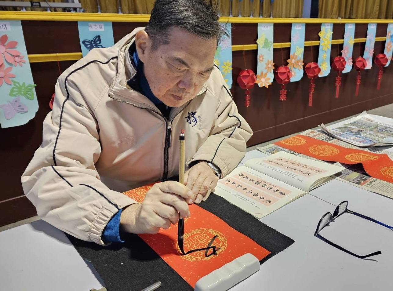 ▲彰化榮家辦理「龍送吉祥迎甲辰－春聯揮毫賀新春」活動，邀請書法名家現場揮毫，吸引住民和職員工大排長龍索取，把有溫度的春聯帶回家。（記者張溎壕攝）