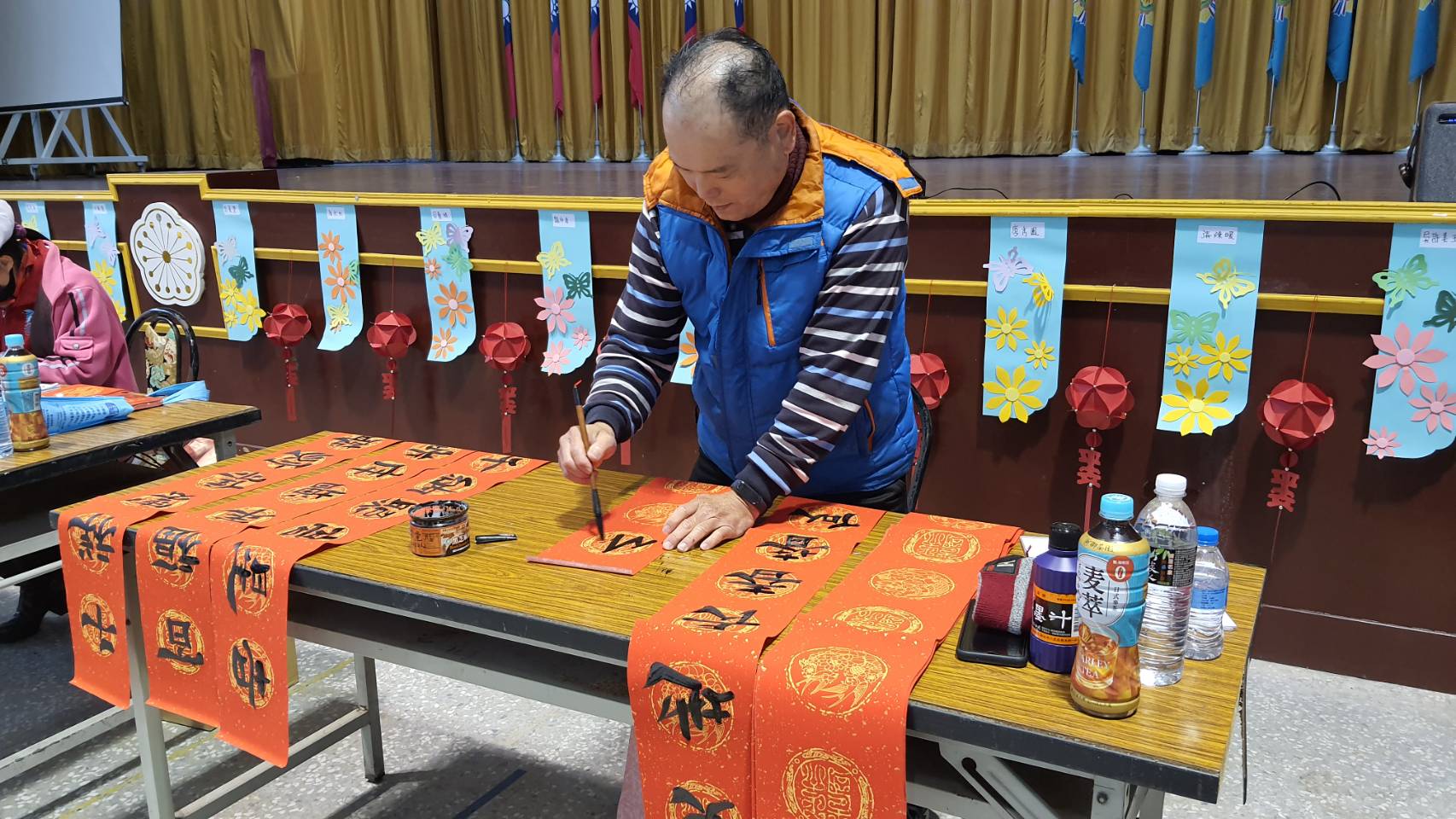 ▲彰化榮家辦理「龍送吉祥迎甲辰－春聯揮毫賀新春」活動，邀請書法名家現場揮毫，吸引住民和職員工大排長龍索取，把有溫度的春聯帶回家。（記者張溎壕攝）