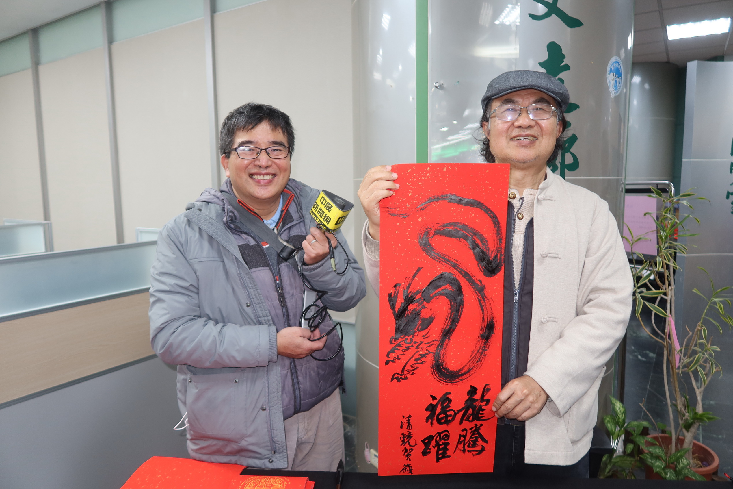 ▲台電彰化區營業處舉辦「好運龍來名家揮毫贈春聯」活動，12位書畫名家現場揮毫，為民眾打造獨一無二的吉祥春聯，吸引眾多鄉親排隊索取熱騰騰的現寫春聯。（記者張溎壕攝）