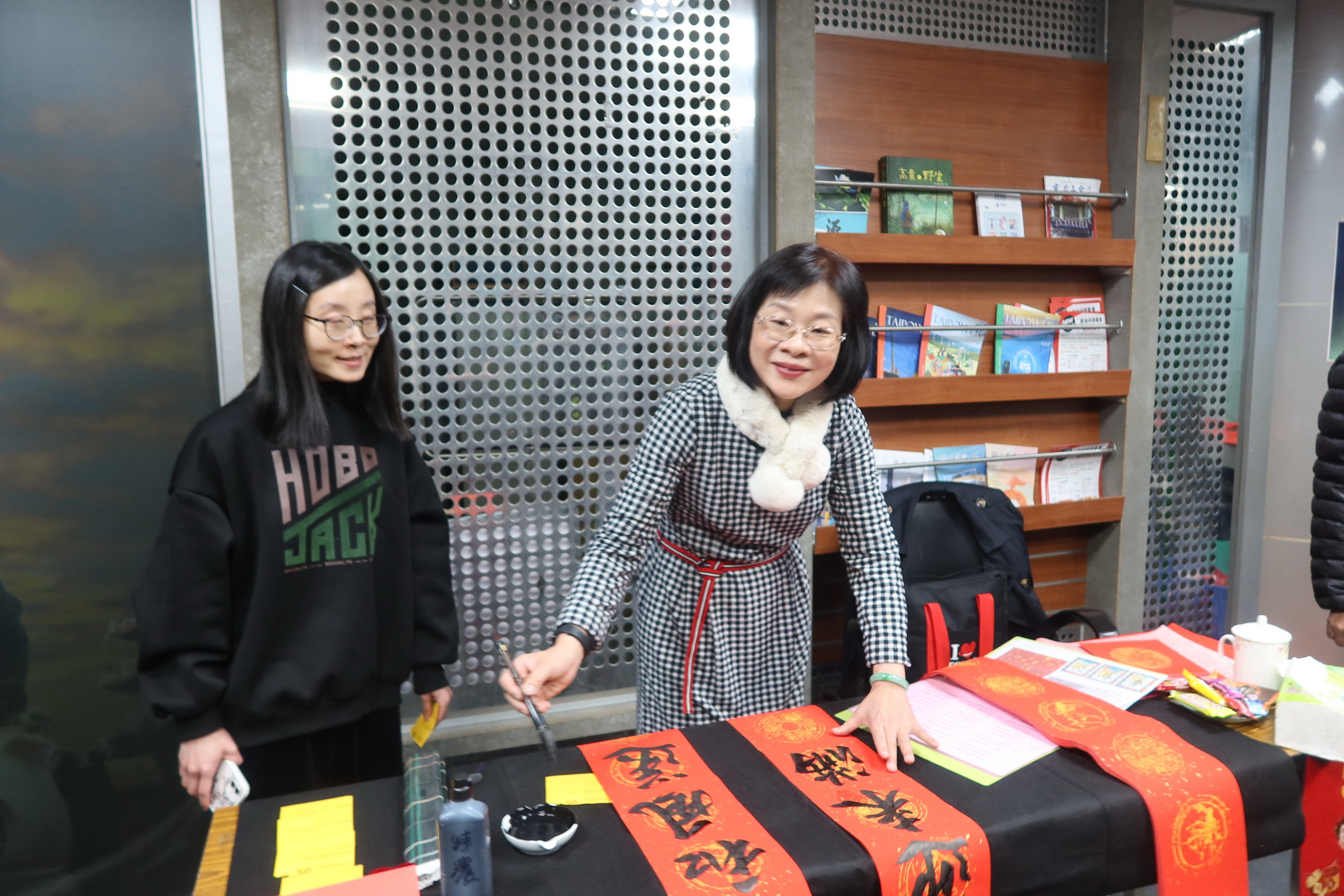 ▲台電彰化區營業處舉辦「好運龍來名家揮毫贈春聯」活動，12位書畫名家現場揮毫，為民眾打造獨一無二的吉祥春聯，吸引眾多鄉親排隊索取熱騰騰的現寫春聯。（記者張溎壕攝）