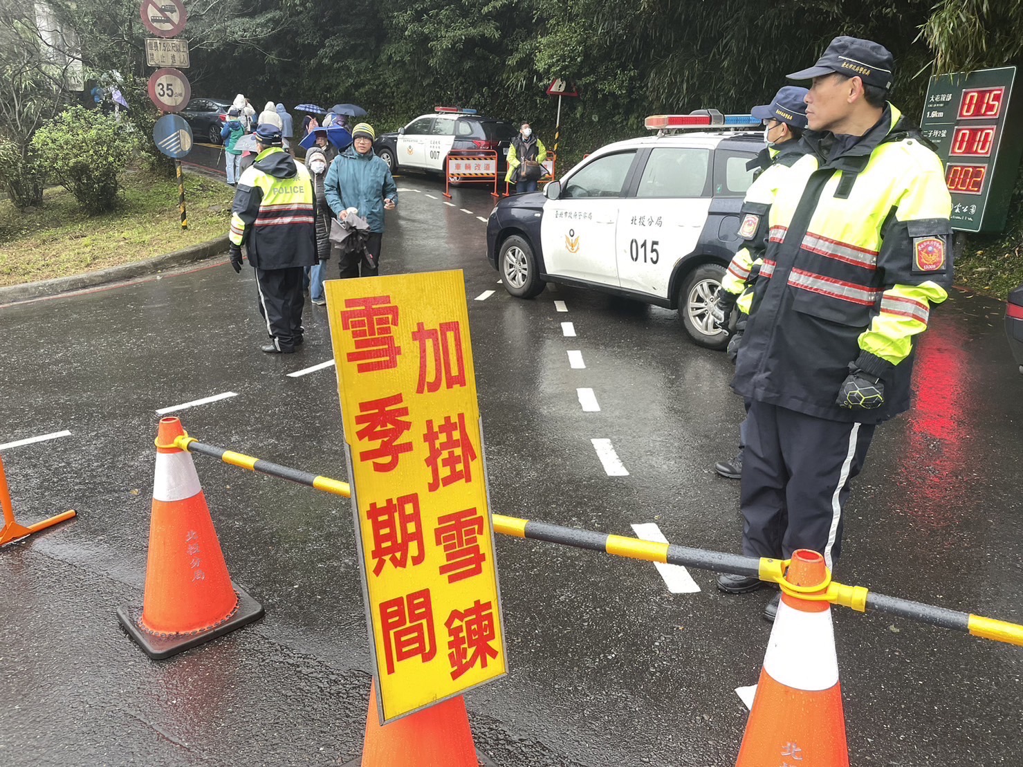 陽明山因寒流來襲降雪,北投分局員警不畏低溫堅守崗位進行交通管制。(記者薛秀蓮翻攝)