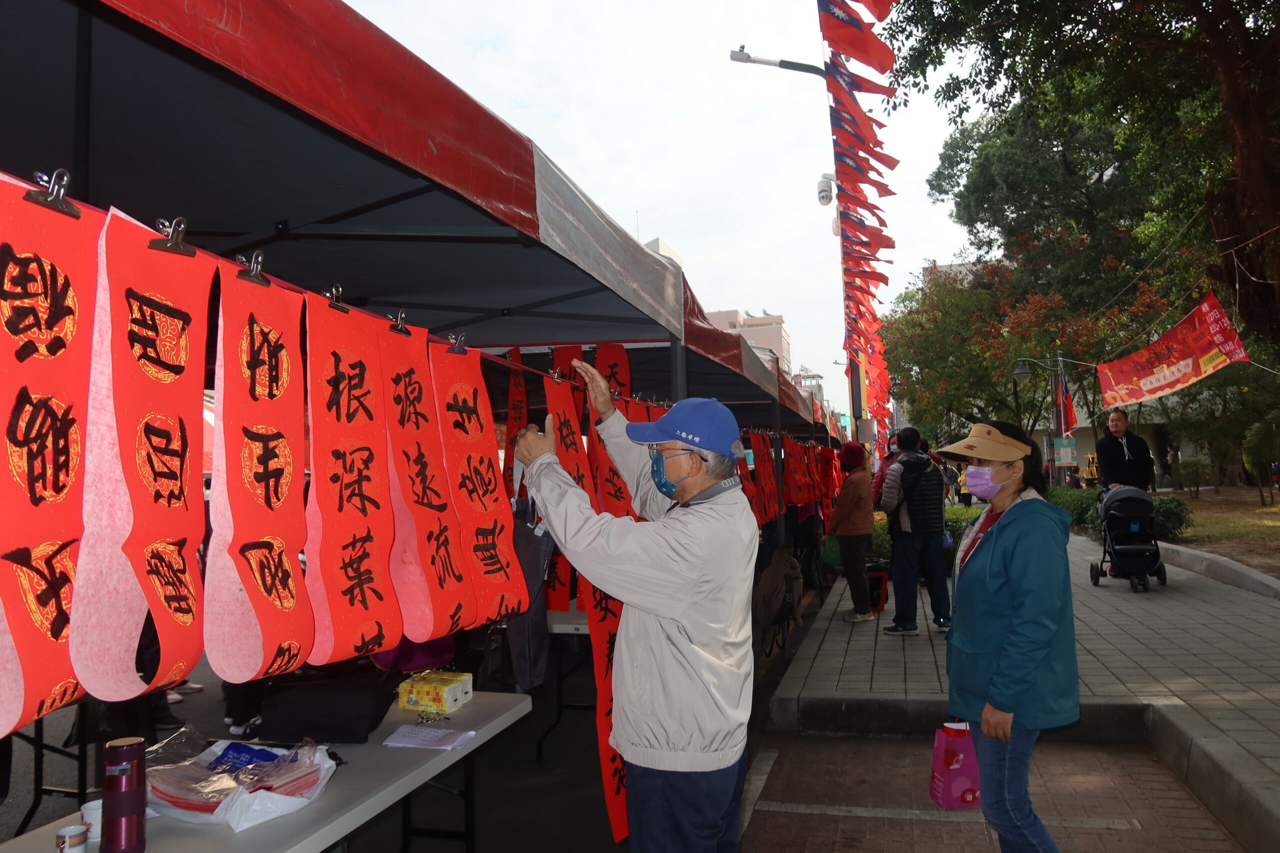▲113年福運龍來‧新春揮毫贈春聯」現場熱鬧登場，20位書法家共同為員林市民寫下千幅手寫春聯，吸引不少民眾一早來排隊免費拿春聯。（記者張溎壕攝）
