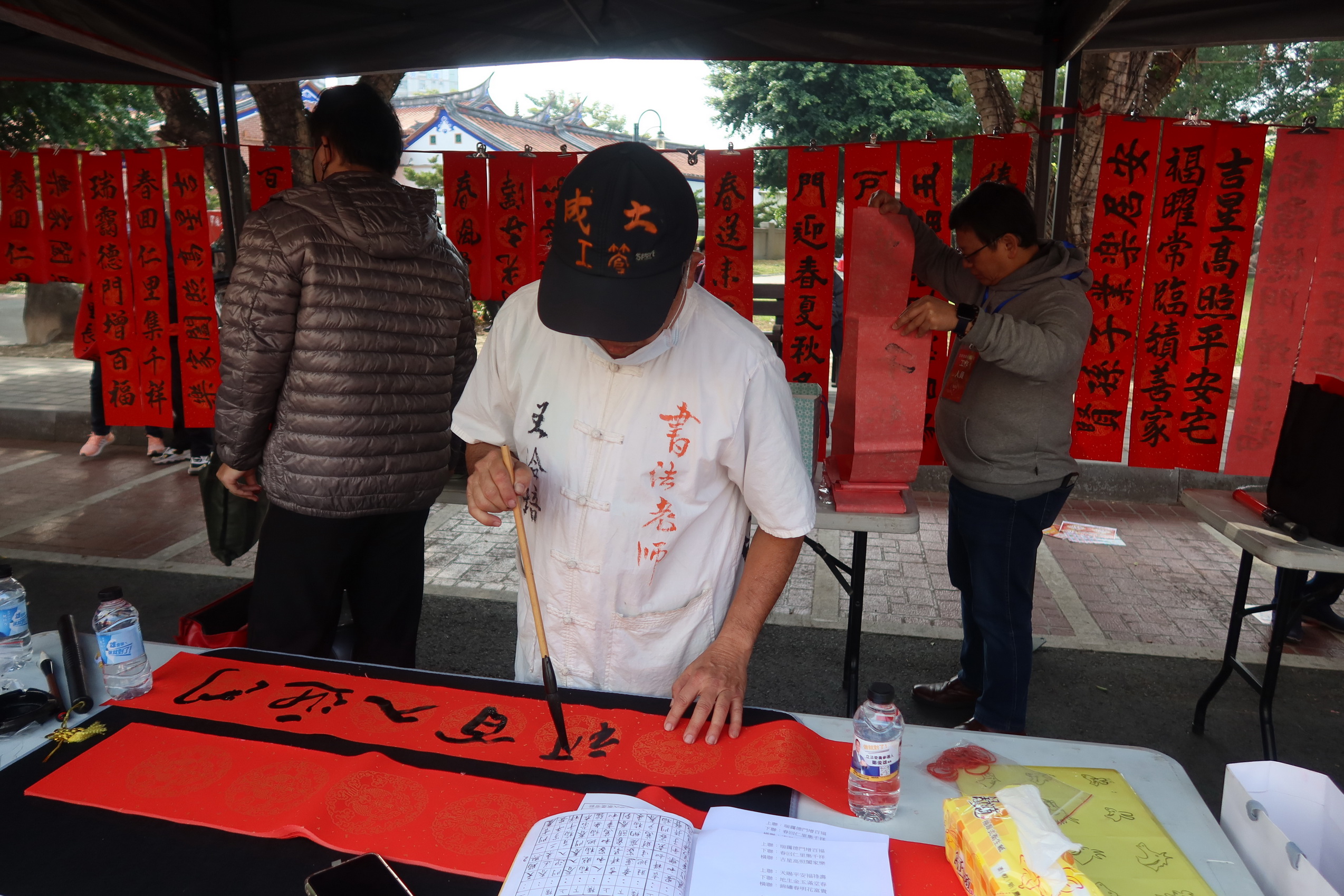 ▲113年福運龍來‧新春揮毫贈春聯」現場熱鬧登場，20位書法家共同為員林市民寫下千幅手寫春聯，吸引不少民眾一早來排隊免費拿春聯。（記者張溎壕攝）