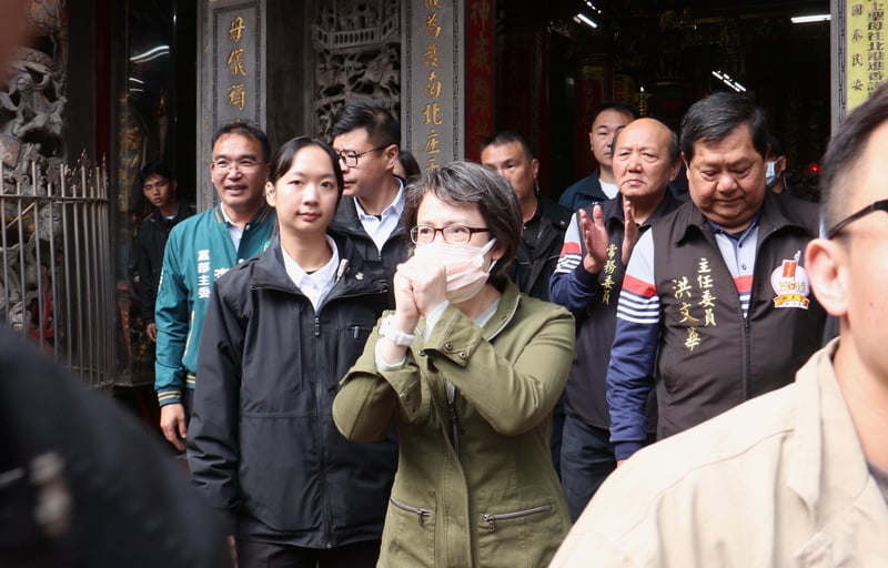 蕭美琴在苗栗在途中發現確診COVID-19,前往白沙屯拱天宮參拜時,戴2層口罩,以拱手代替握手向民眾致意。 中央社