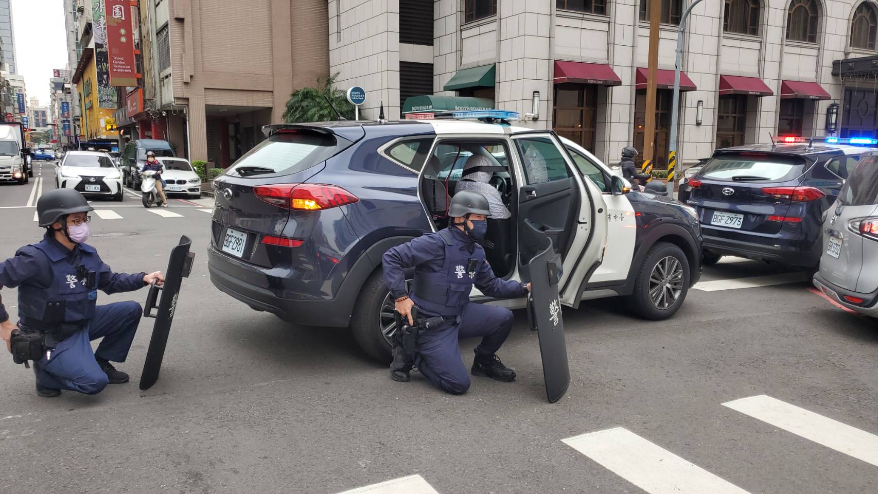 ▲圖說:員警接獲銀行搶劫通報後,荷槍實彈抵達銀行大門前戒備 (圖/台中市政府提供)