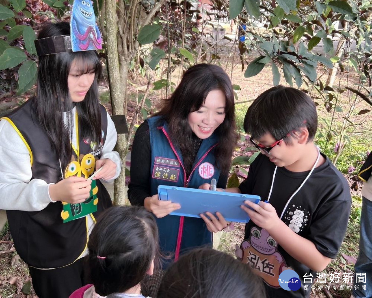 青年事務局局長與孩童共同體驗你畫我猜遊戲。