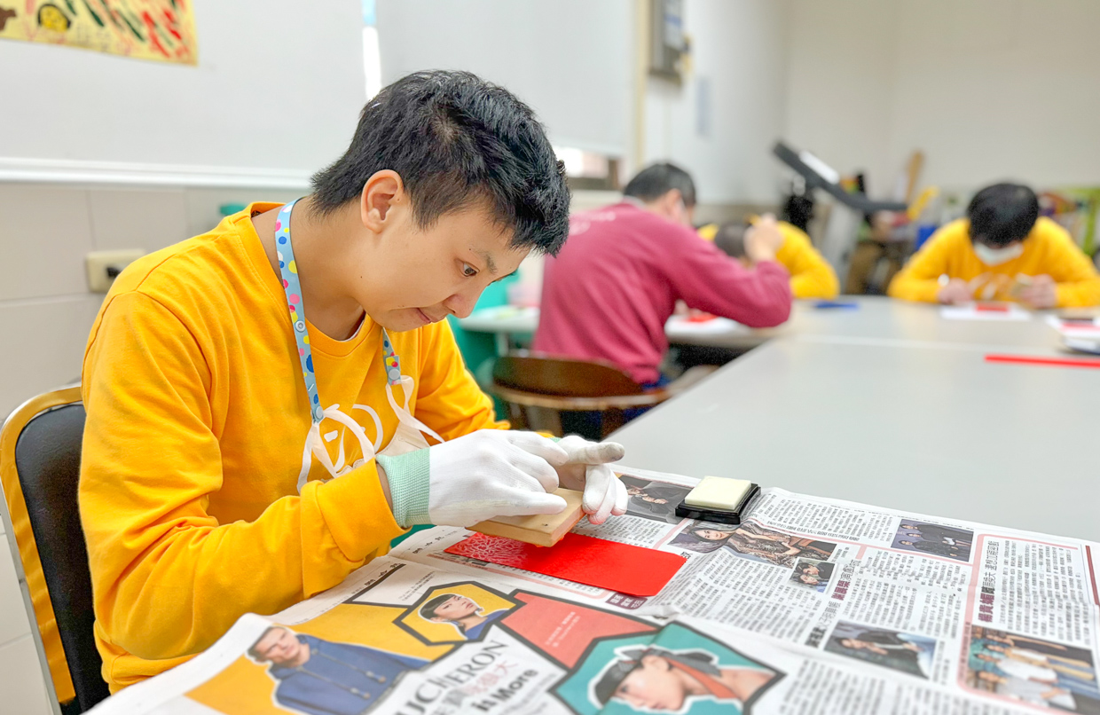 ▲小希對準紅包袋蓋上圖案章。（圖/喜憨兒提供）
