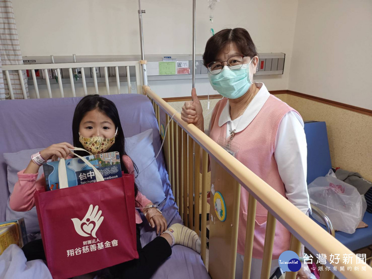 翔谷慈善基金會到童醫院,李宜靜護理長協助送禮物給病童。