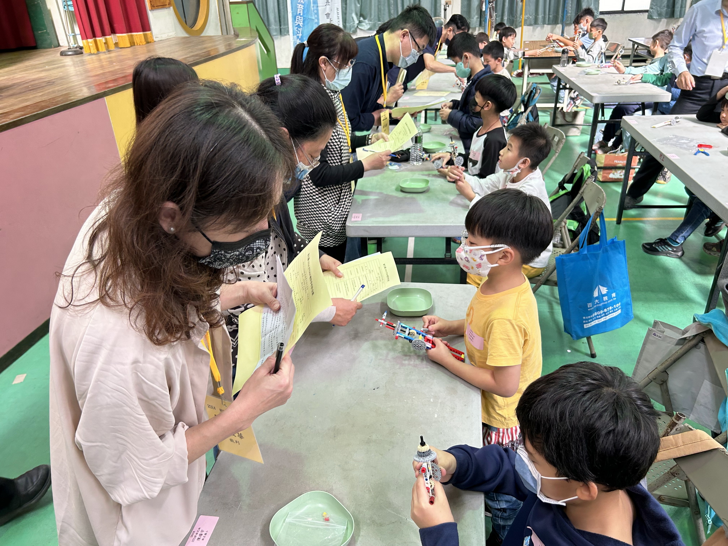 ▲彰化縣首場AI STEAM創意實作檢定競賽在大村鄉村上國小舉行,一百多名小學生齊聚活動中心,進行認知檢測和主題實作應用比賽。(記者張溎壕攝)