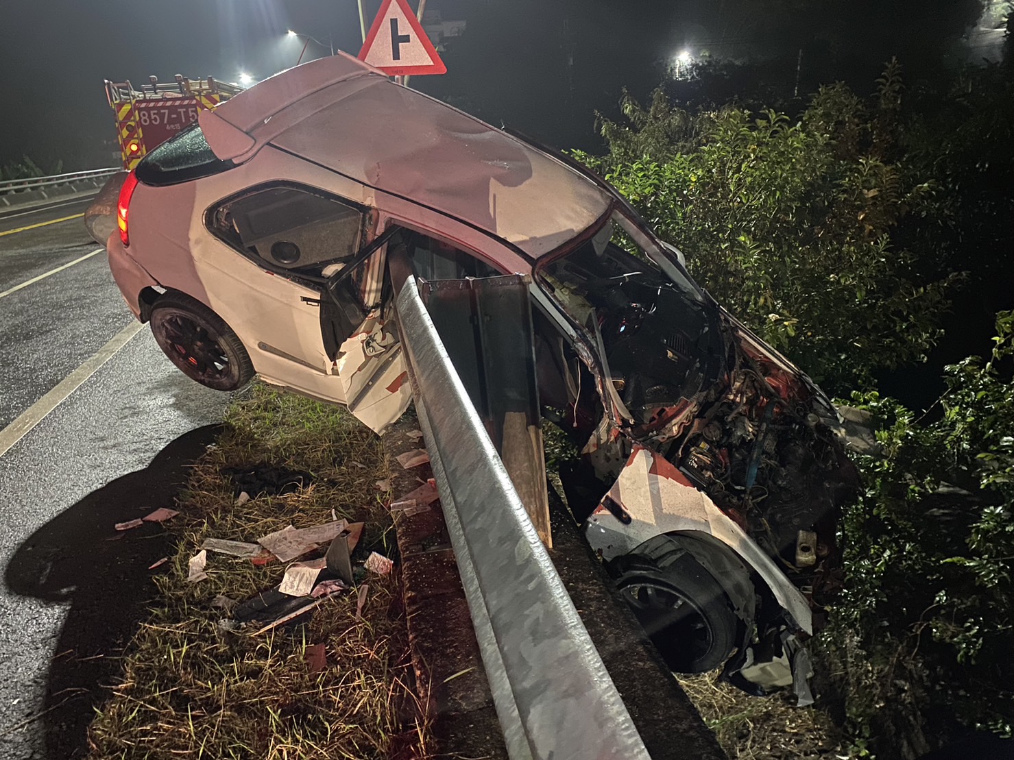 ▲自小客車體一半衝出車道斜卡在護欄，消防人員卻遍尋不到駕駛人。（圖／民眾提供）