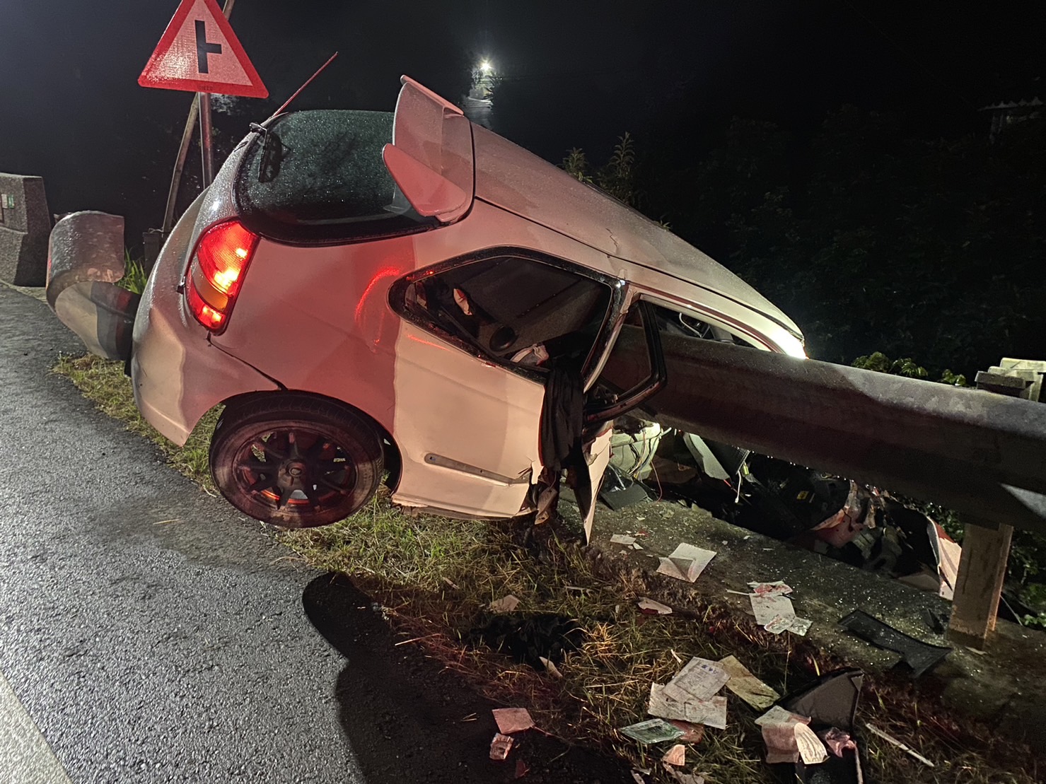 ▲自小客車體一半衝出車道斜卡在護欄，消防人員卻遍尋不到駕駛人。（圖／民眾提供）