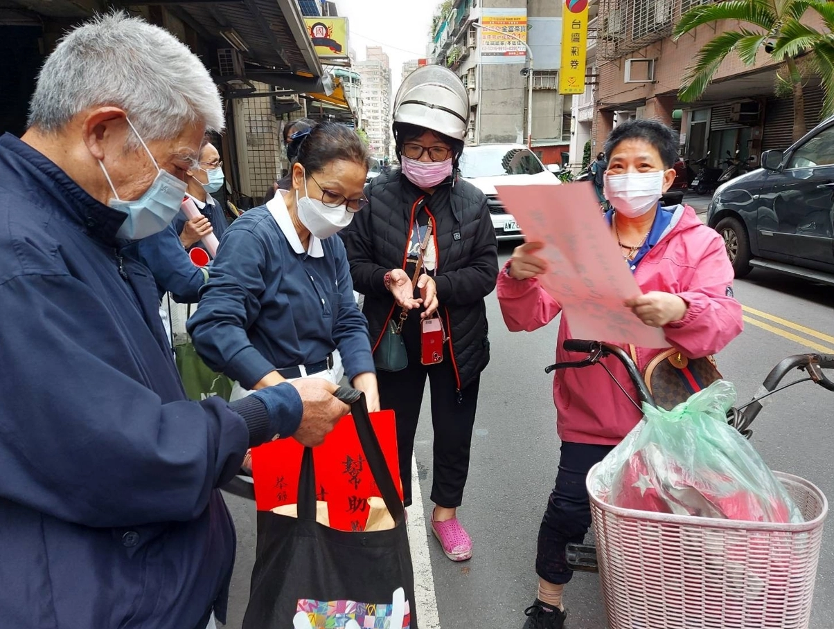 社區民眾向慈濟志工索取靜思語春聯,一起傳遞祝福好話。