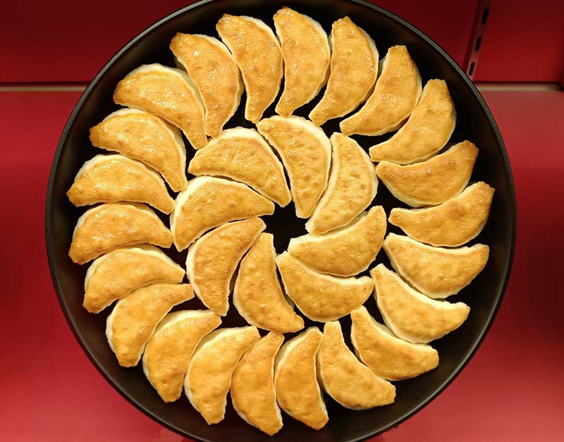 將煎餃子的鐵鍋直接端上桌,這就生產鋼鐵的小倉特色。