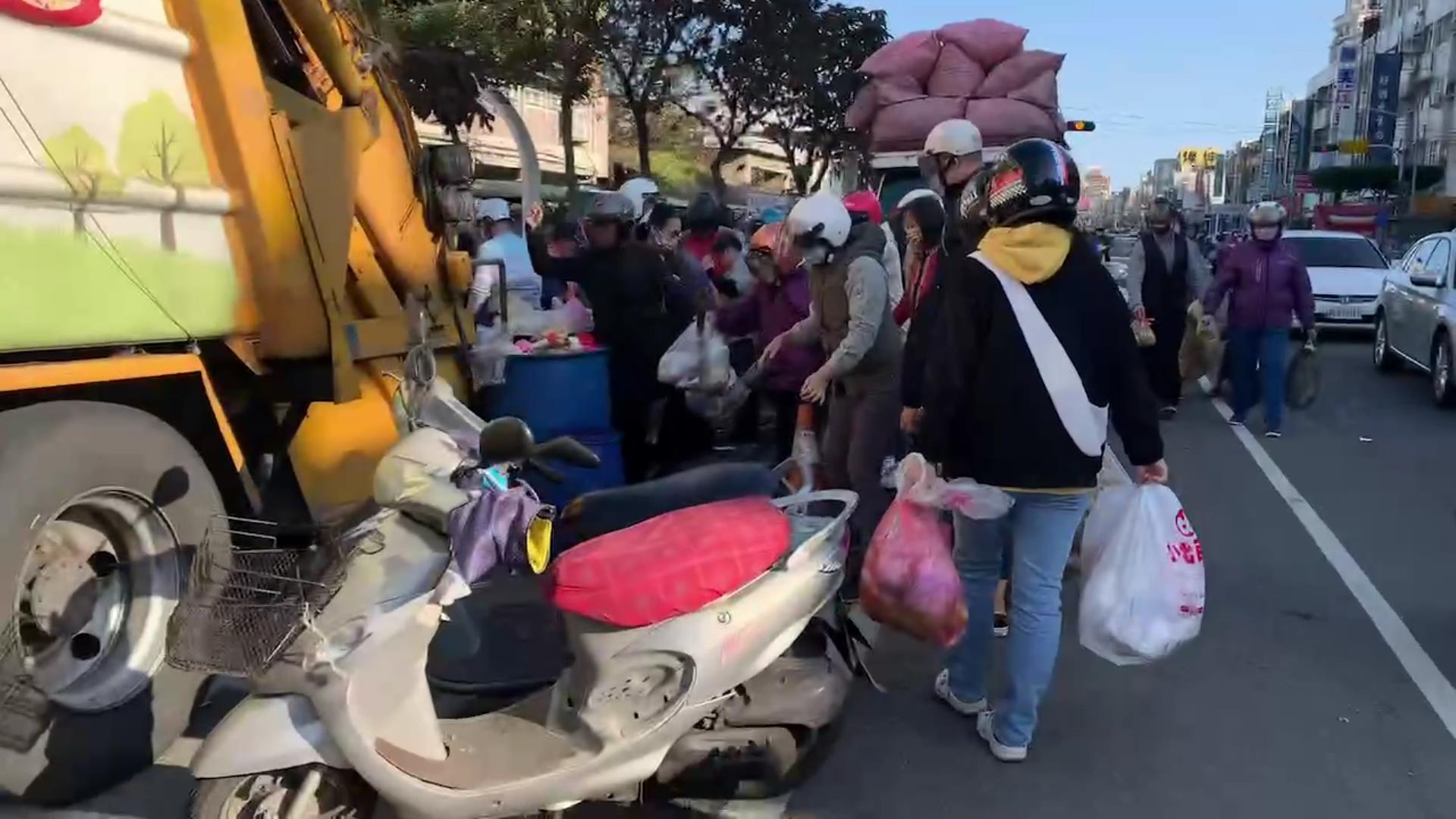 ▲春節假期彰化市停收垃圾4天，今天起恢復清運，市區街頭各個清運點都出現大批丟垃圾人潮，清潔隊員忙得不可開交。（記者張溎壕攝）