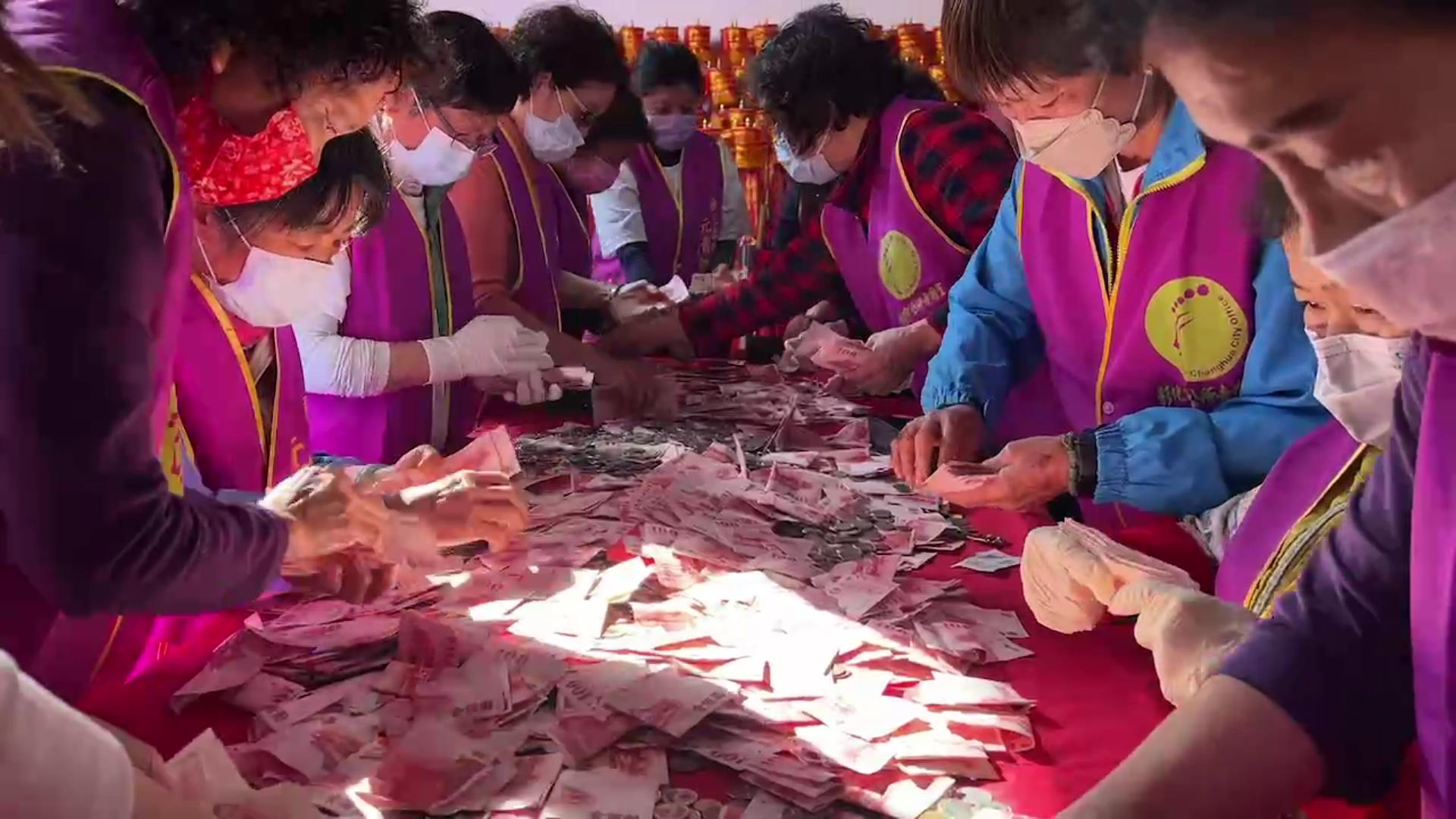 ▲俗稱「天公壇」國定古蹟彰化市元清觀,大年初七打開功德箱進行清點,滿滿的香油錢倒滿了桌面,志工人員忙著數錢,整個清點過程全程採直播錄影。(記者張溎壕攝)