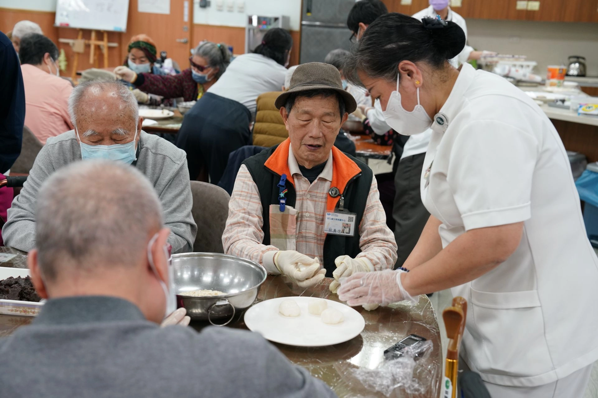 花蓮慈院日間照顧整合中心主任張幸齡(右一),細心指導長輩做元宵。