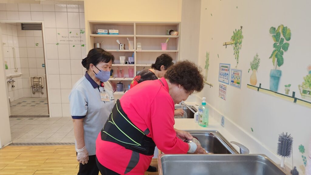 午餐後在日照員陪同下長者們自己動手洗碗,長者們會互相幫助有人洗碗有人收拾餐具。(圖/慈濟清水日照中心提供)