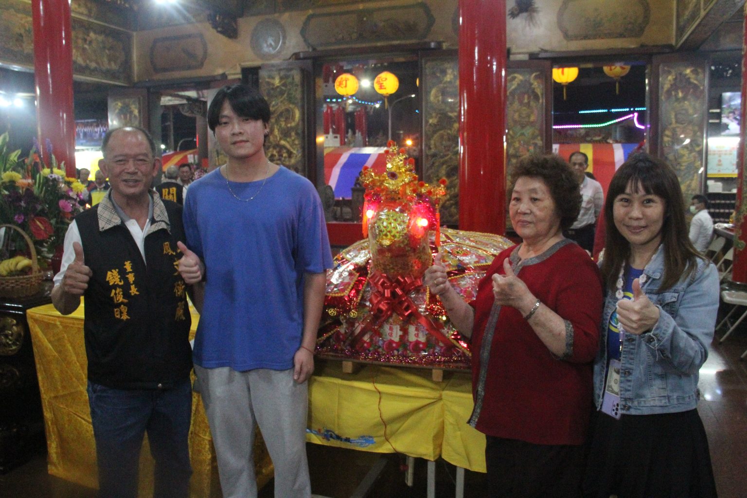 ▲由年僅十一歲的楊同學抱黃金「金關帝」，十七歲高二學生王子宸請回一百六十台斤重的龜王。（廟方提供）