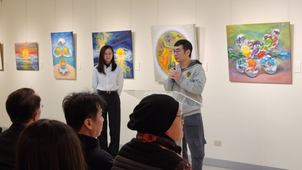 策展人林佳鴻老師致詞,後面展出的蛋畫作品有藝思!(圖/陳惠玲攝影)