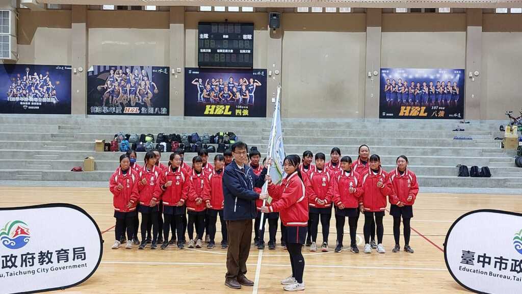 ▲教育局長為東山國中部女壘隊授旗,預祝旗開得勝-。(台中市政府提供)