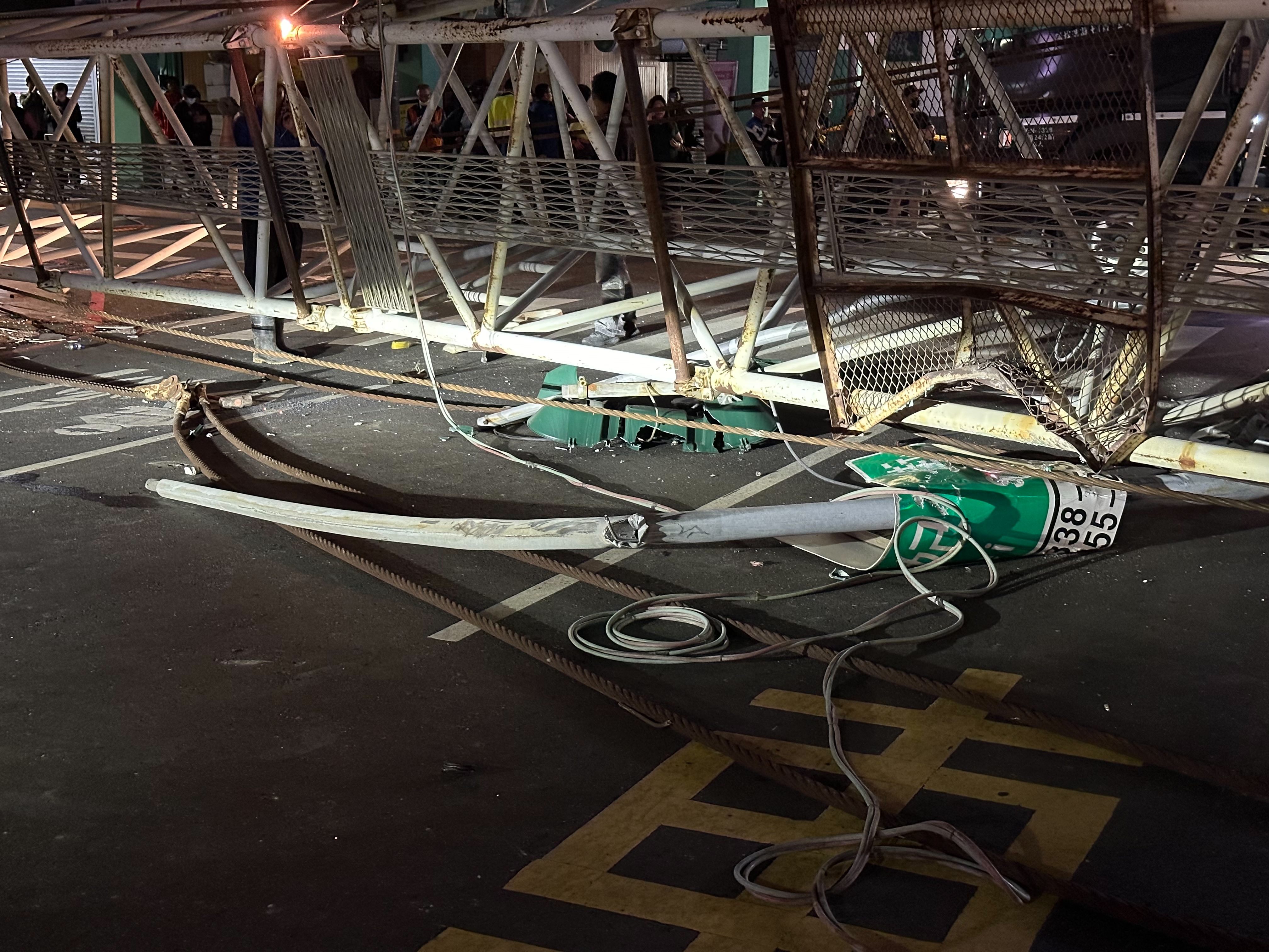 台南建案的天坑再出意外，協助拖吊的大型吊車，因傾斜重心不穩翻覆，吊臂橫跨西門路面。記者陳聖璋／攝影