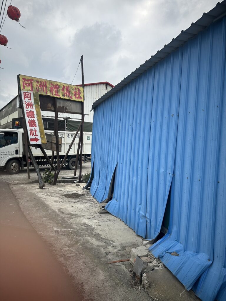 一位男子開賓士車，行經台中市大甲區興安路時，疑似超車，撞上停在路邊貨車後，再失控撞貨櫃屋，造成賓士車頭全毀，駕駛受傷送醫。(畫面翻攝)