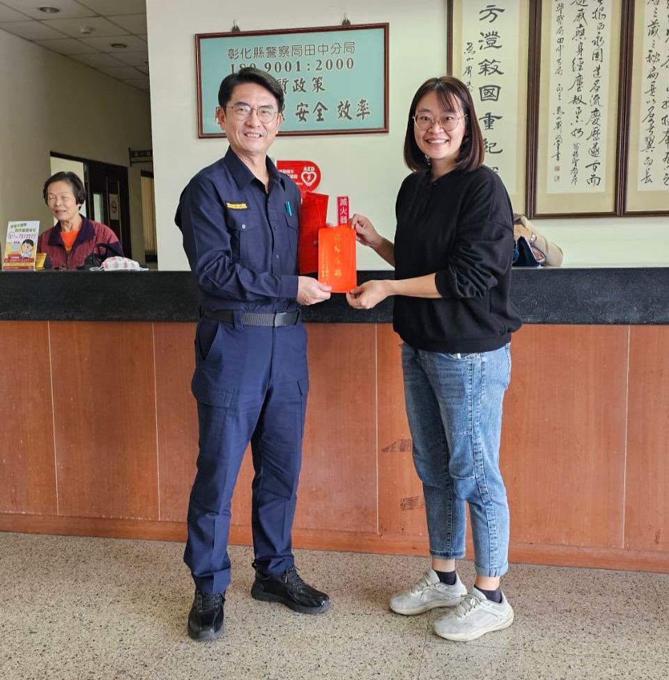 ▲田中警分局長簡龍宏與警友辦事處副主任陳瑞德共同贈送每位女性員工禮卷，慰勞並祝賀婦女節快樂。（記者張溎壕攝）