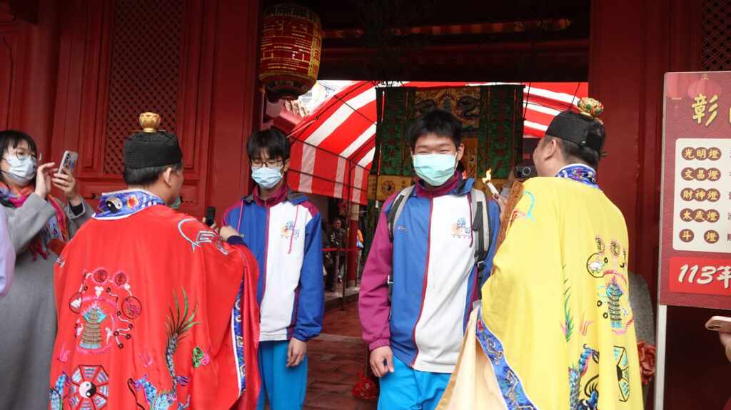 ▲祝壽團拜後,由道師及林市長帶領參加學子過開運文昌橋,上橋前淨身、下橋後由道師為每位參加者加持。(記者林明佑攝)