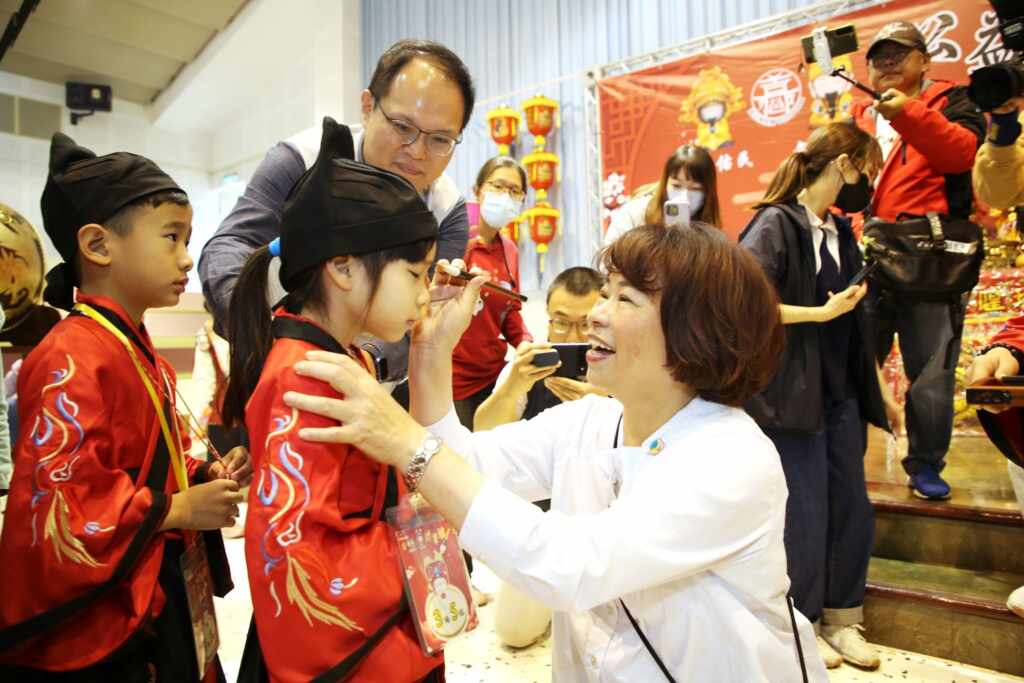 ▲第六屆「城隍佑民·文昌護子」公益古禮抓周暨文昌「開筆禮」活動,嘉義市長黃敏惠擔任啟蒙老師為孩子們點硃砂。(嘉義市社會處提供)
