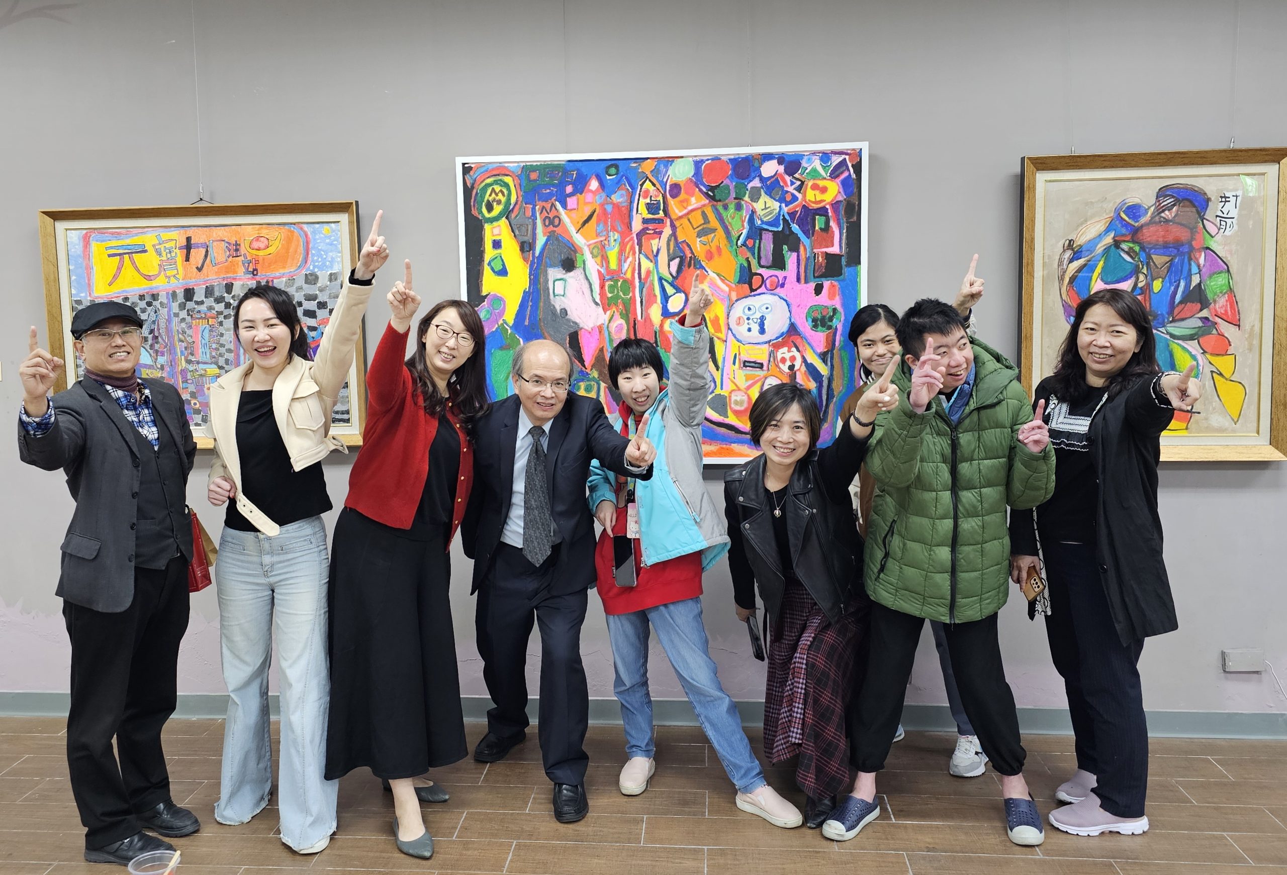 文山特殊教育學校校長葉宗青(左四)帶領師生與台灣天使藝術家發展協會創會理事長黃詩芬(右四)在藝文畫廊介紹、分享學生們的作品。(記者黃荷琇 拍攝)