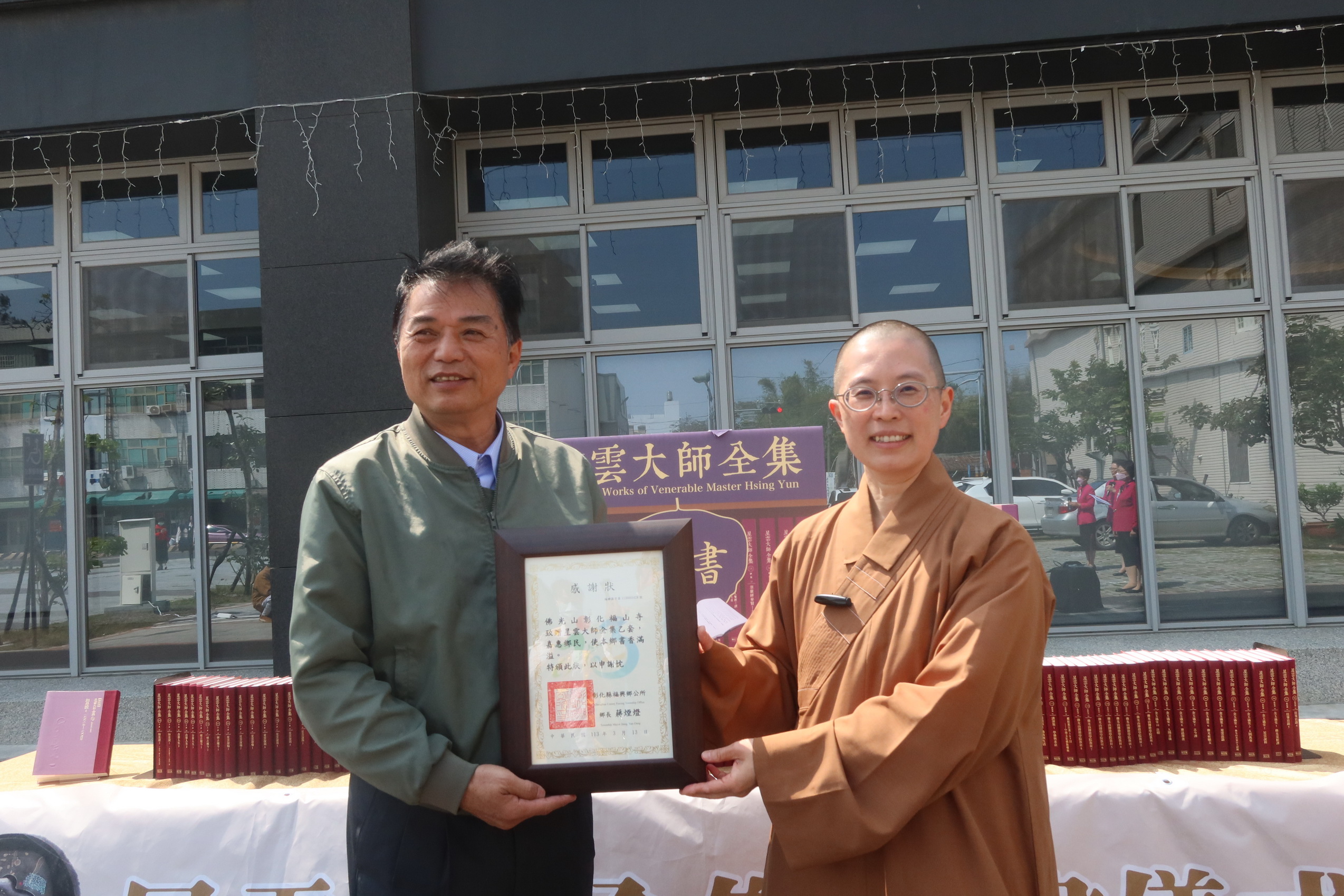 ▲佛光山彰化福山寺住持妙宥法師將《星雲大師全集》致贈給福興鄉立圖書館，由鄉長蔣煙燈代表接受並致贈感狀。（記者張溎壕攝）