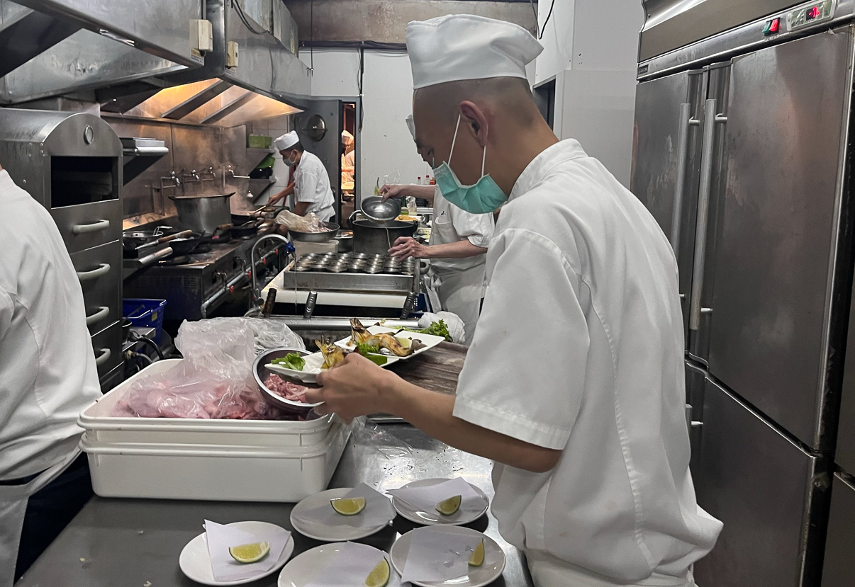 ▲阿緯在廚房擺盤準備出菜。(圖/喜憨兒基金會提供)