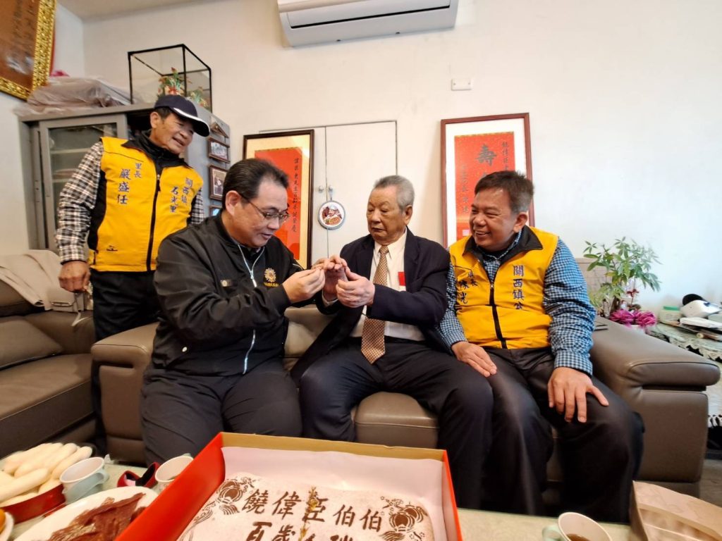 鞠宗顯處長為饒爺爺戴上紀念金戒子。(圖/記者黃溎芬翻攝)