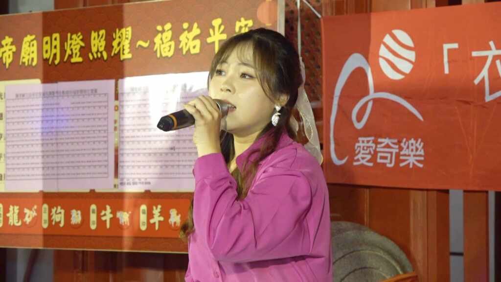 ▲歌手吳美琳在彰化市關帝廟前熱情開唱。(記者林明佑攝)