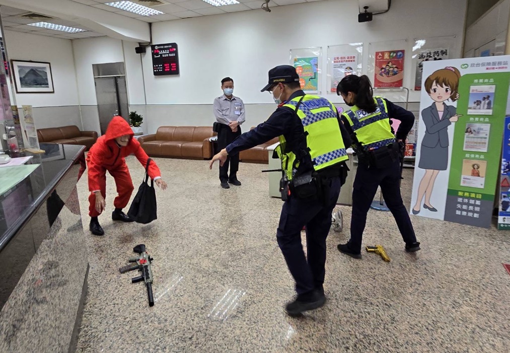 ▲圖說:警方接獲銀行報案,員警「荷槍實彈」,以優勢警力衝入銀行壓制劫匪棄械投降 (圖/台中市政府提供)