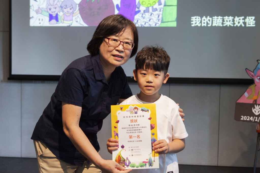 ▲ 台中市新聞局副局長陳瑜(左)頒發小畫家比賽第一名獎狀,並與得獎小畫家合影。(台中市政府提供)