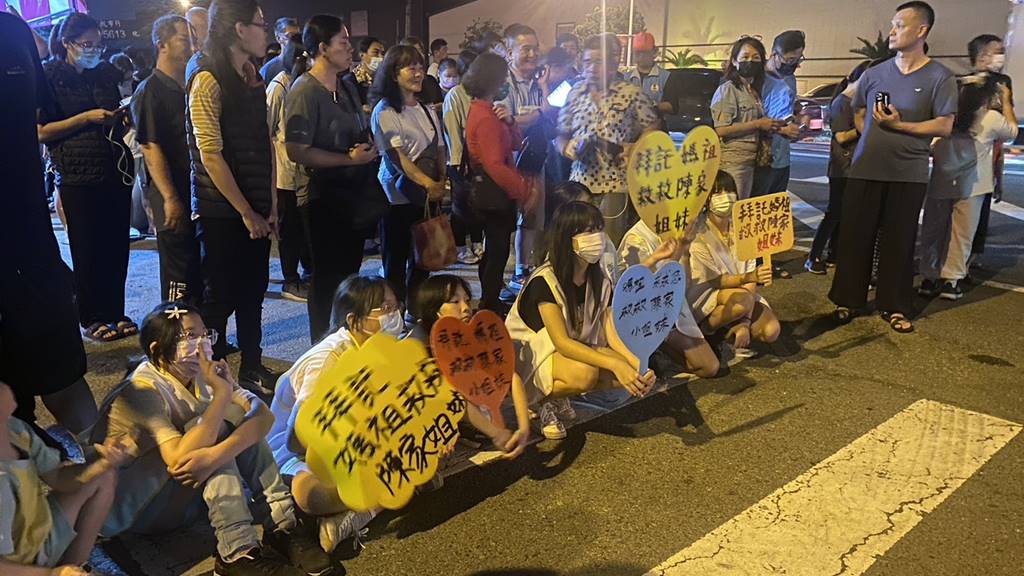 ▲許多陳家姊弟同學們,在路口等候「粉紅超跑」,並跪著高喊「拜託媽祖救救陳家姊妹」,粉紅超跑媽祖鑾轎大約10時25分通過,並未停駕。(記者林明佑翻攝)