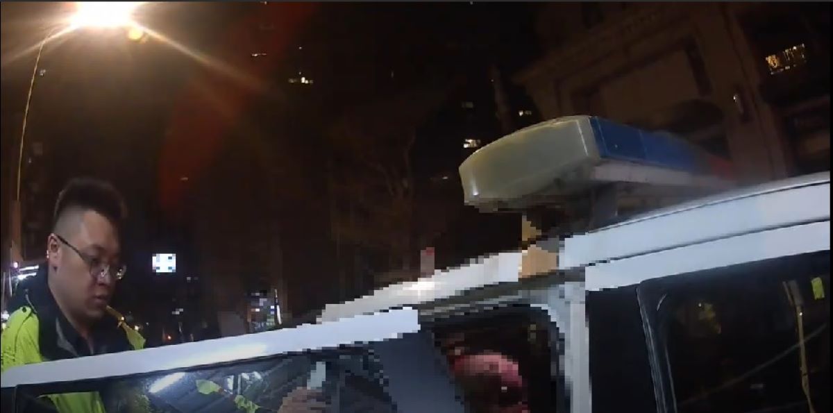 警方攙扶老婦上警車。（記者薛秀蓮翻攝)