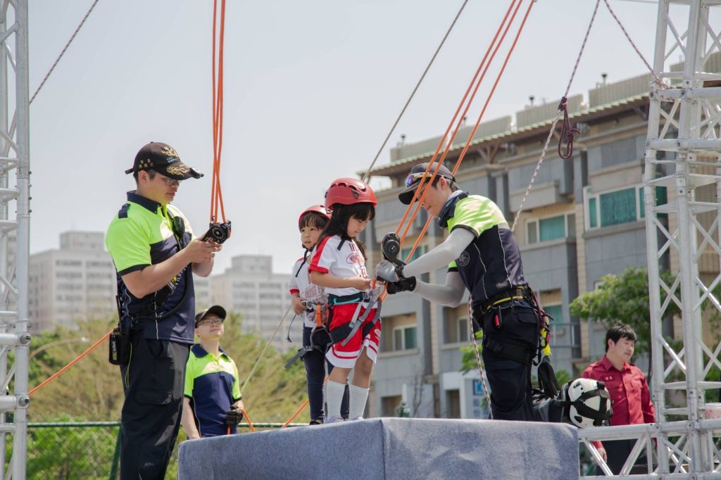 消防員教導孩童進行橫渡滑索，透過寓教於樂學習防災應變技能。（圖/記者黃溎芬翻攝）