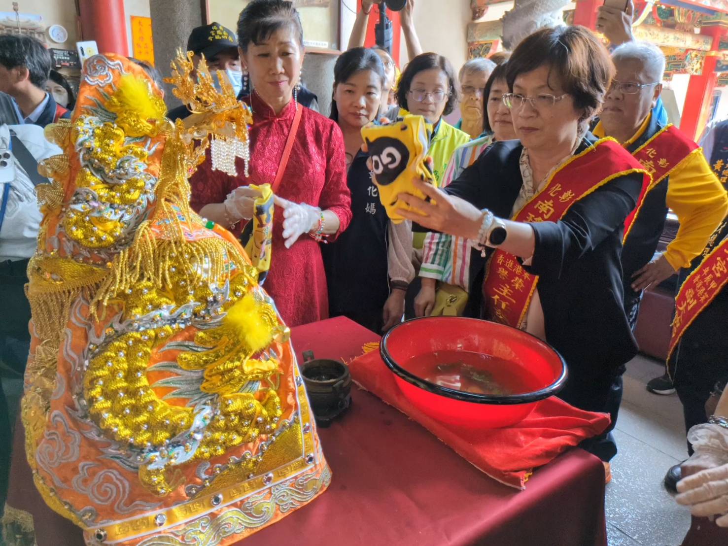 ▲彰化南瑤宮笨港進香「百年徒步古香路之行」，彰化縣長王惠美、彰化市長林世賢夫人高德耘等人恭謹地為媽祖換穿龍袍，神聖溫馨儀式原汁原味呈現。（記者張溎壕翻攝）