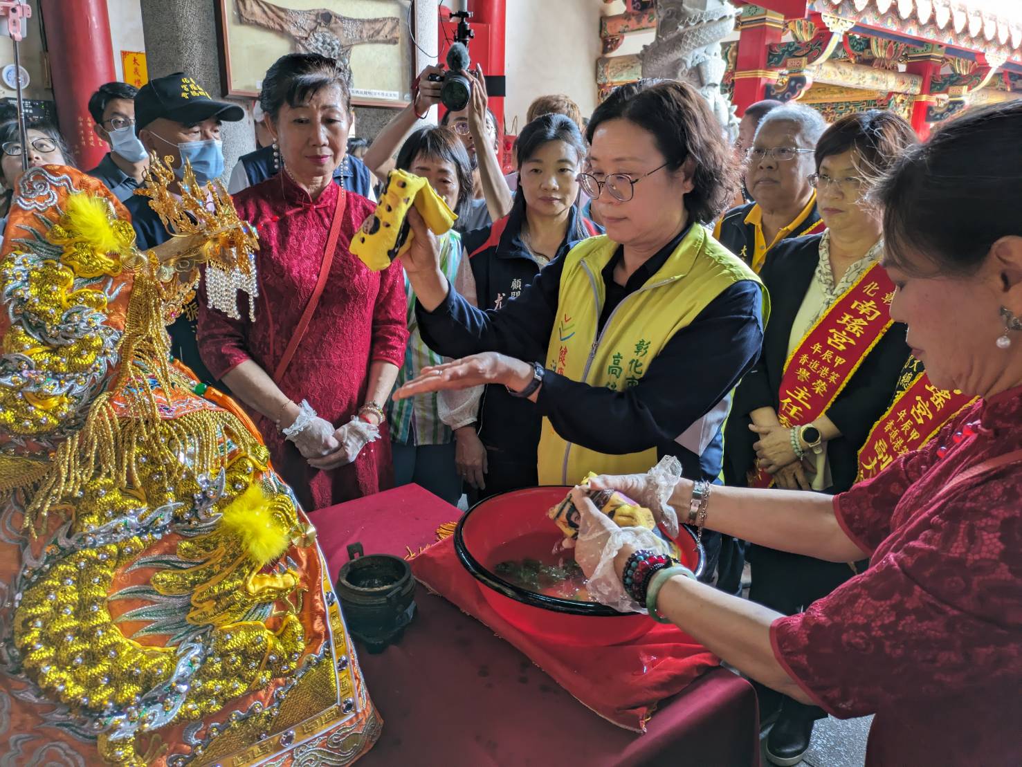 ▲彰化南瑤宮笨港進香「百年徒步古香路之行」，彰化縣長王惠美、彰化市長林世賢夫人高德耘等人恭謹地為媽祖換穿龍袍，神聖溫馨儀式原汁原味呈現。（記者張溎壕翻攝）