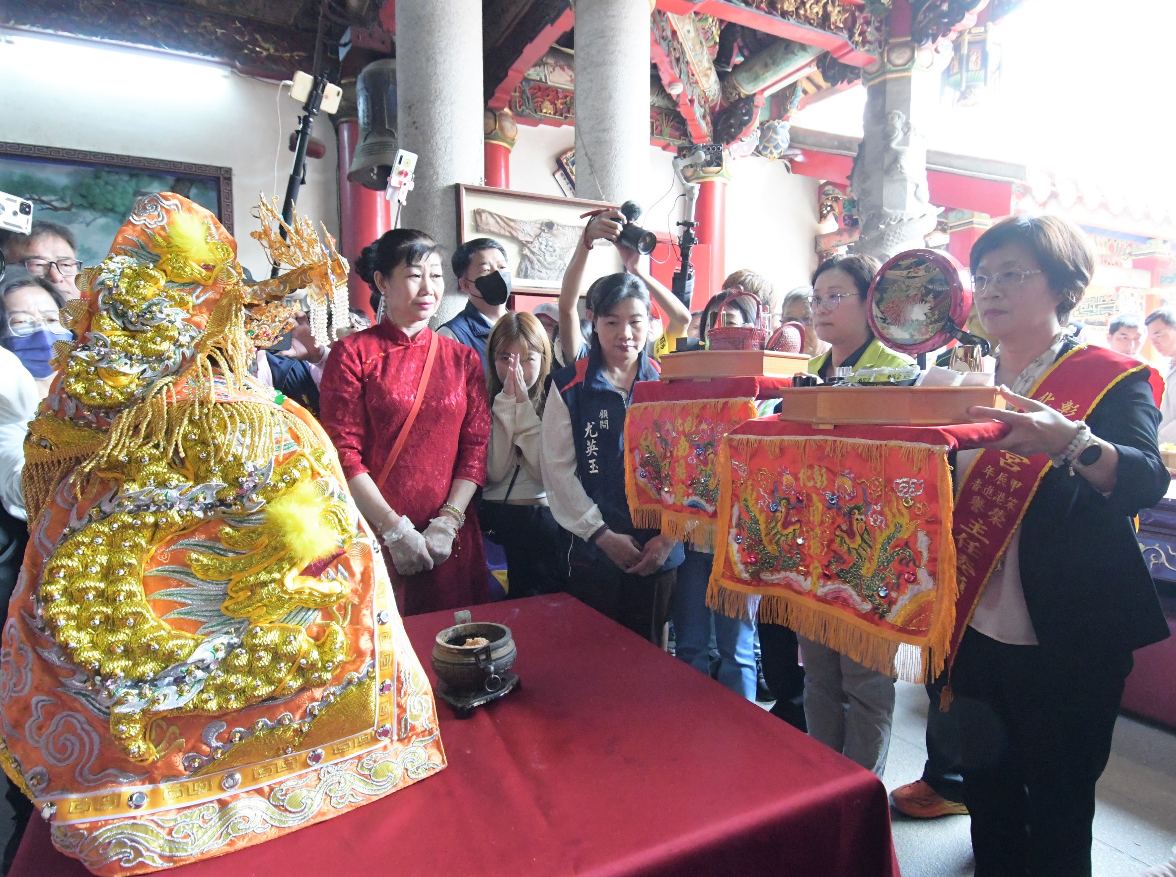 ▲彰化南瑤宮笨港進香「百年徒步古香路之行」，彰化縣長王惠美、彰化市長林世賢夫人高德耘等人恭謹地為媽祖換穿龍袍，神聖溫馨儀式原汁原味呈現。（記者張溎壕翻攝）