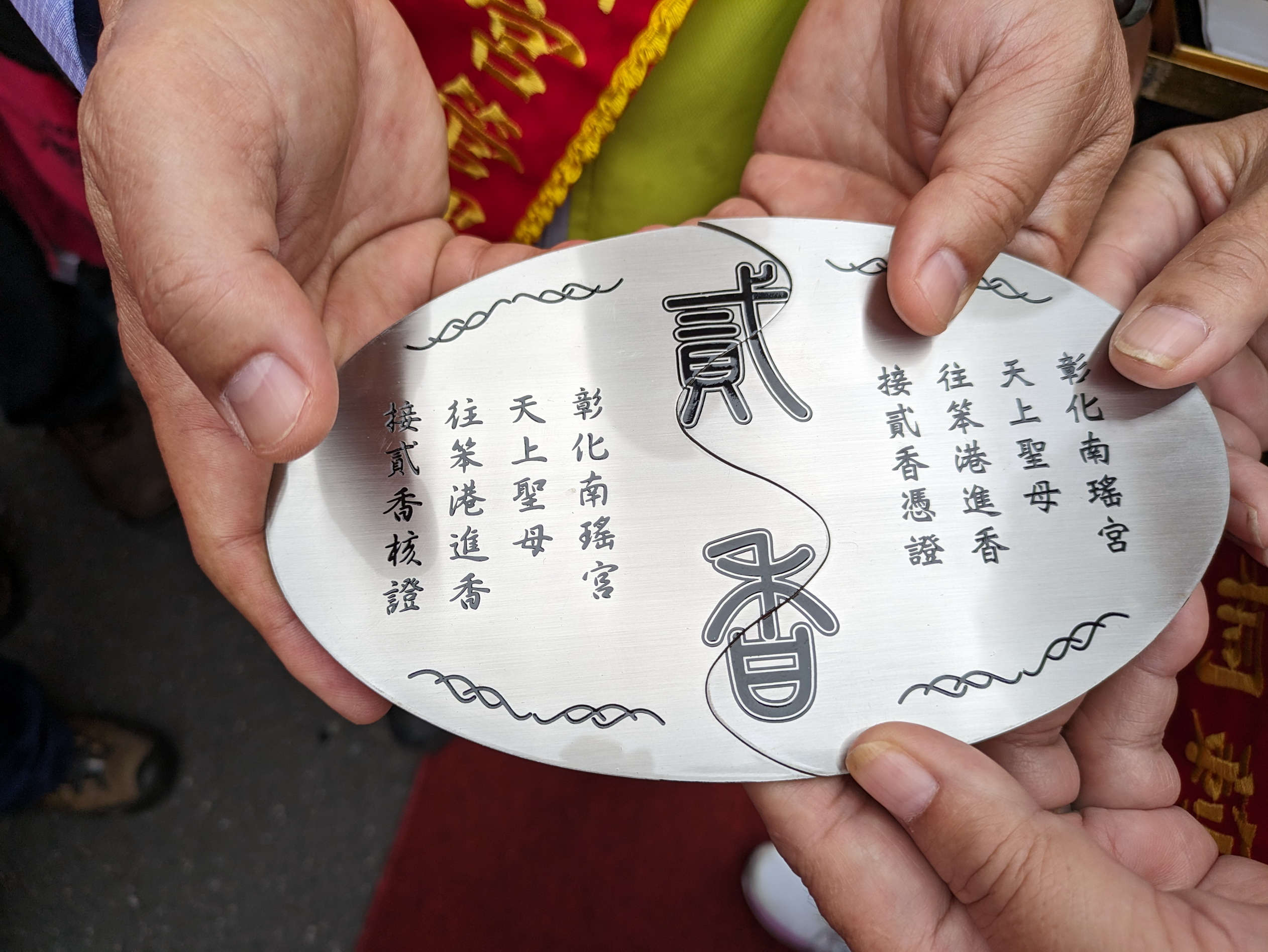 ▲彰化南瑤宮往笨港進香活動，由進香主委林世賢和南瑤宮分香宮廟-莿桐天瑤宮主委林味珍，各拿出半邊的仿古銀牌信物，完成核對與併攏的儀式。（彰化市公所提供）