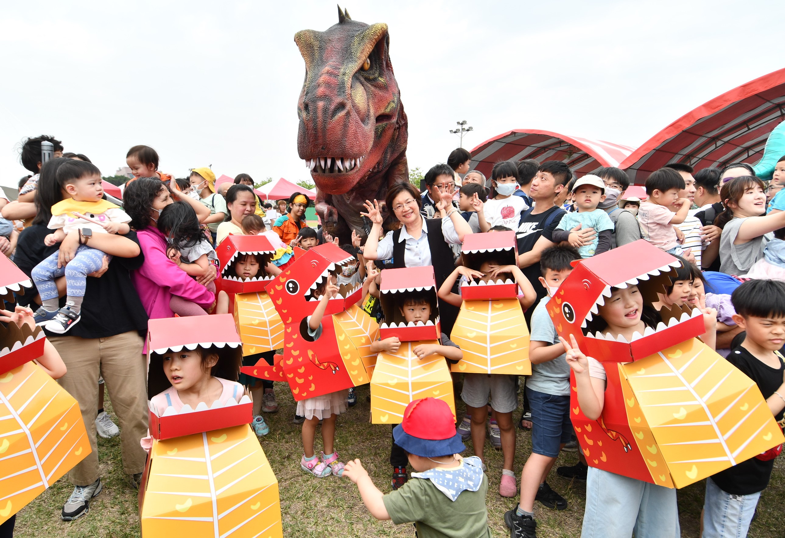 ▲彰化囝仔好幸福恐龍嬉遊記，3000多名親子齊聚鎮立體育場，活動如同侏儸紀公園般，模型暴龍穿梭於會場，引起現場觀眾陣陣驚呼與歡笑。（記者張溎壕攝）