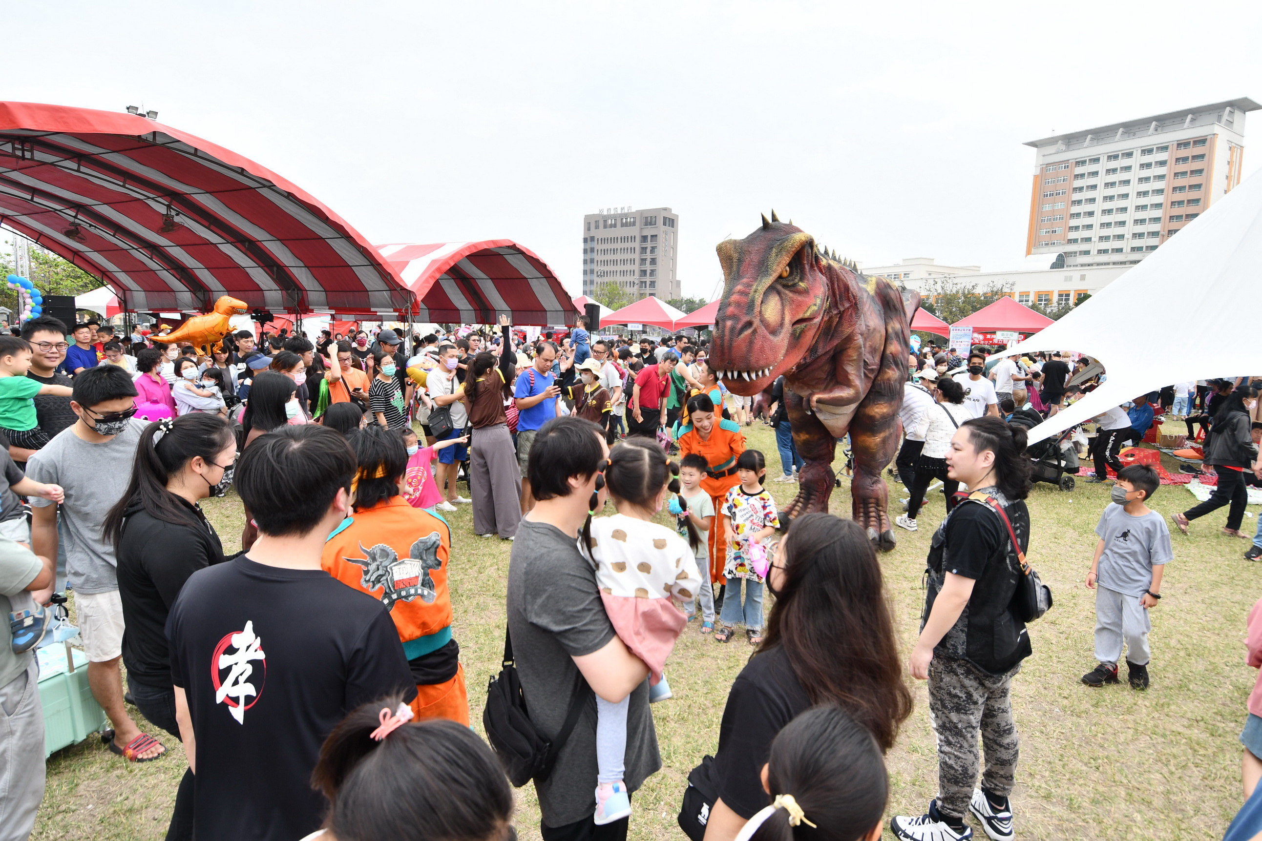 ▲彰化囝仔好幸福恐龍嬉遊記，3000多名親子齊聚鎮立體育場，活動如同侏儸紀公園般，模型暴龍穿梭於會場，引起現場觀眾陣陣驚呼與歡笑。（記者張溎壕攝）