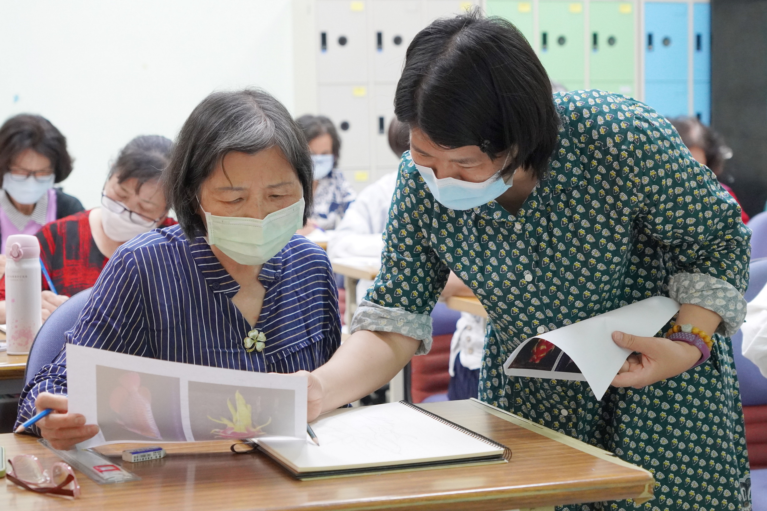 ▲李一芳老師(右)指導大葉大學長青大學色鉛筆生活彩繪班學員創作。(記者張溎壕攝)