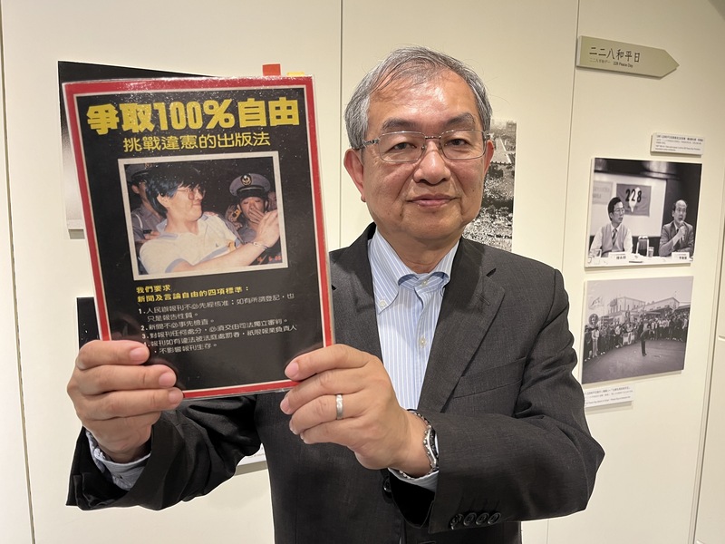 鄭南榕胞弟、國際特赦組織台灣分會理事鄭清華手持一本以前由鄭南榕出版、印有標語「爭取100%自由」的《自由時代》週刊,於鄭南榕基金會.紀念館留影。圖/中央社
