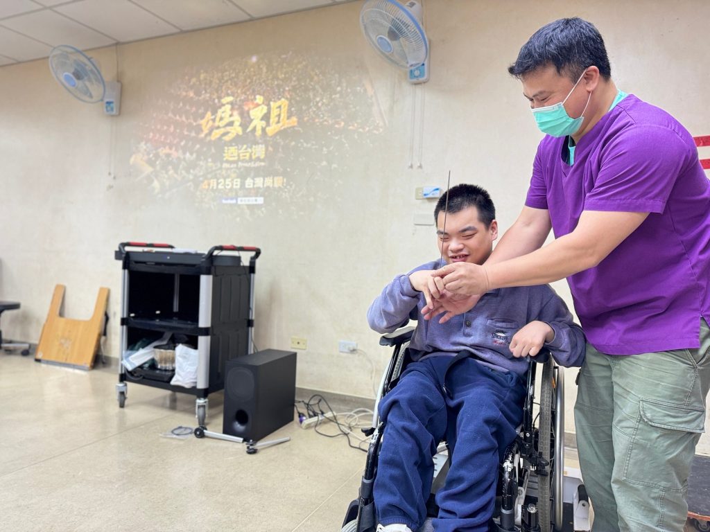 治療師點上線香,讓院生小軒左向媽祖祈求家人平安健康。(圖/新北市政府提供)