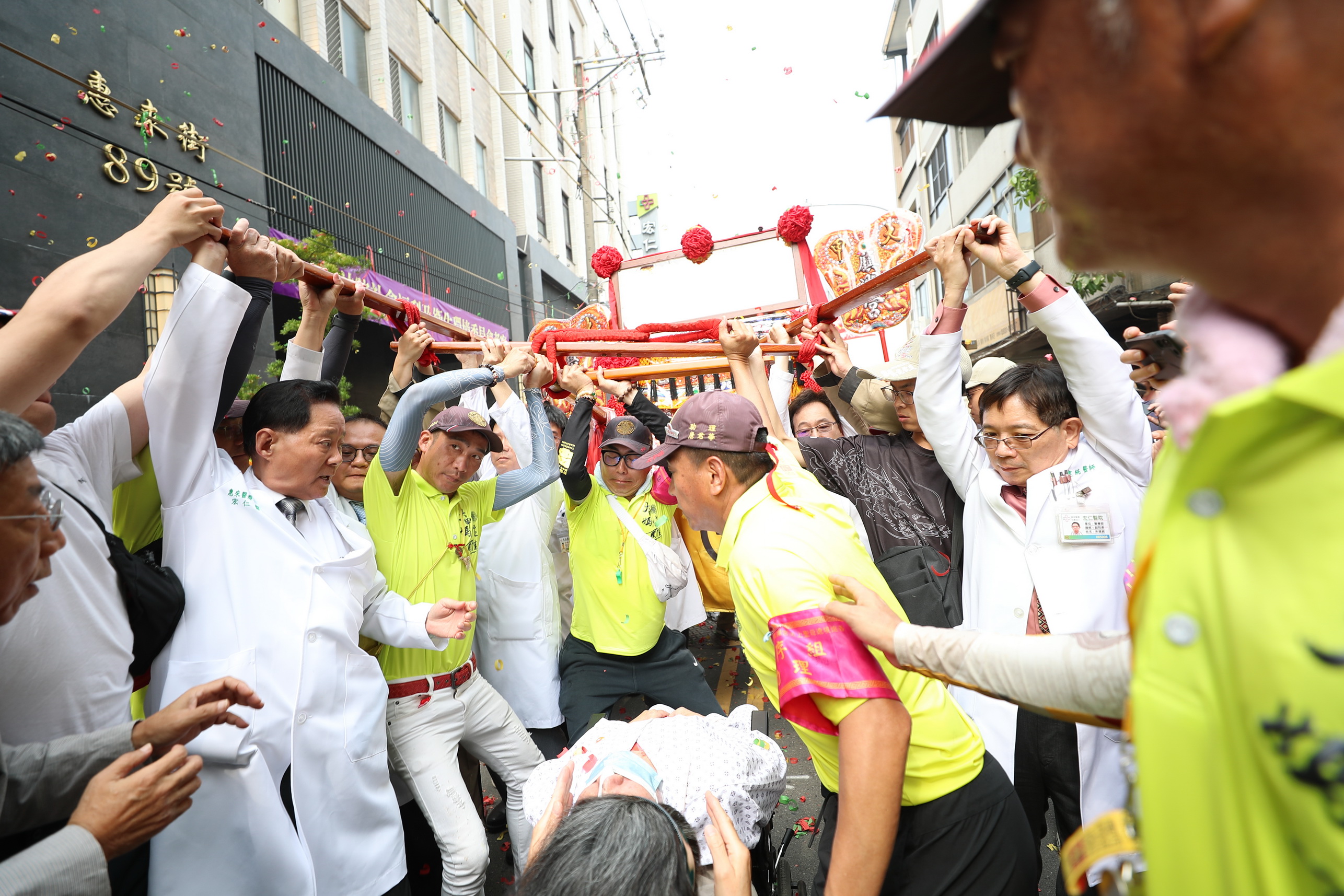 ▲大甲媽鑾轎回鑾停駕員林市宏仁醫院，多位白袍醫師扛轎祈福，院方也設置點心站，並設置醫療站服務香客傷痛問題。（宏仁醫院提供）