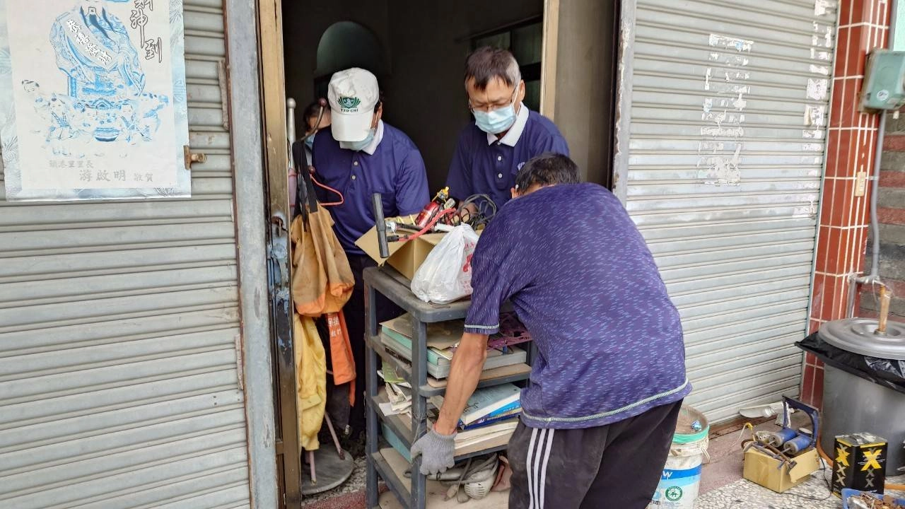 環境髒亂,志工動員打掃居家環境,把屋內的桌椅及物品一一搬運出來。